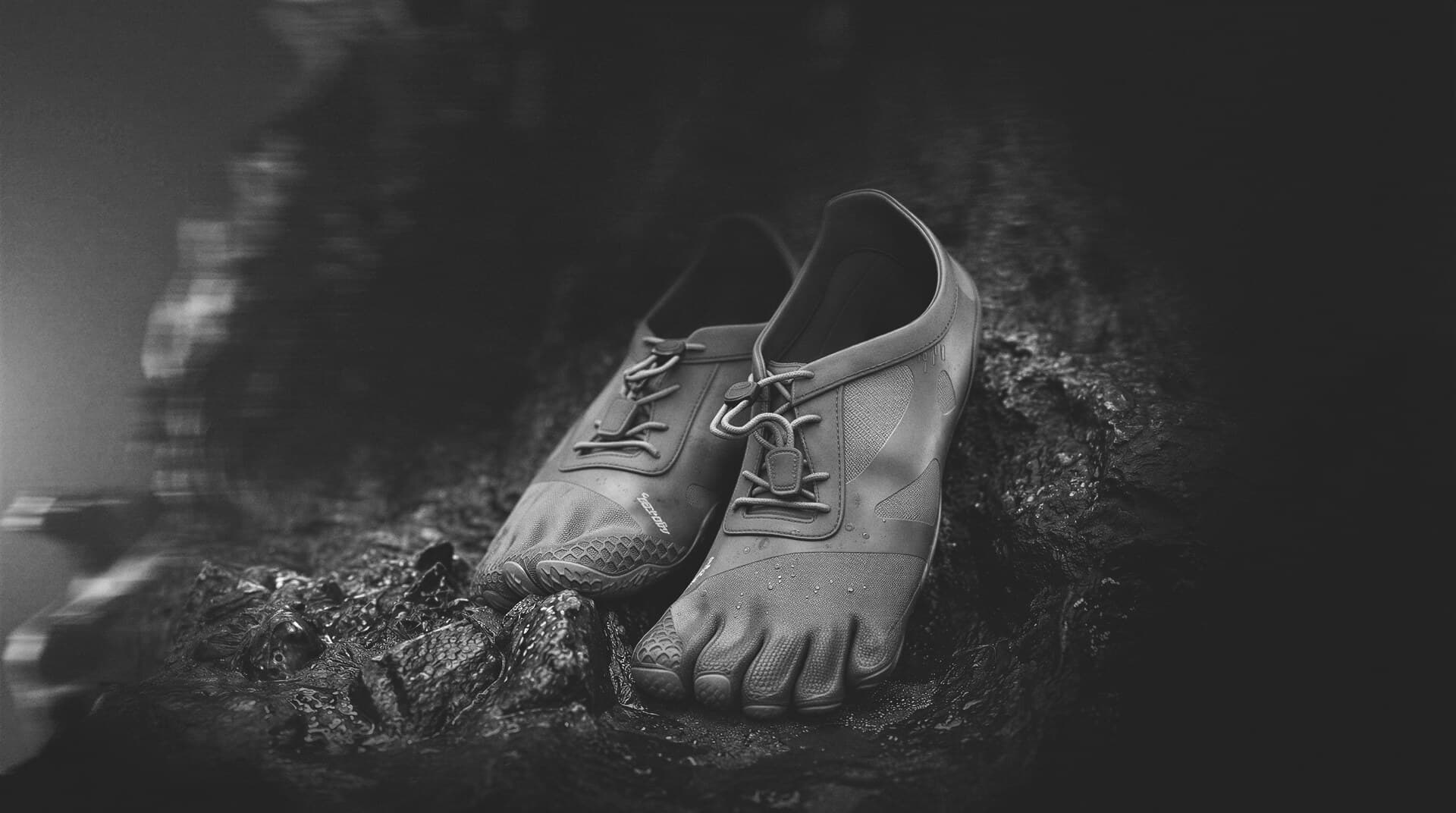 Barefoot shoe on wet rock, black and white study